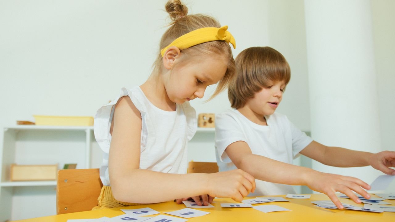 Mastering the First Impression: Your intriguing post title goes here Two young children engaged in a fun learning activity indoors, focusing on letters.