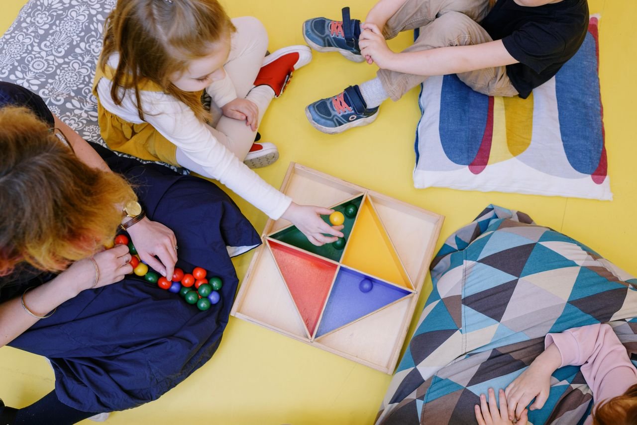 Hello world! Kids engaged in playful learning with colorful toys in a vibrant playroom setting.